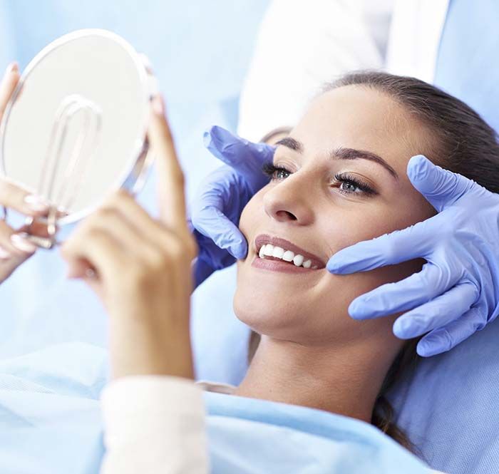 Mujer mira el resultado de su tratamiento dental
